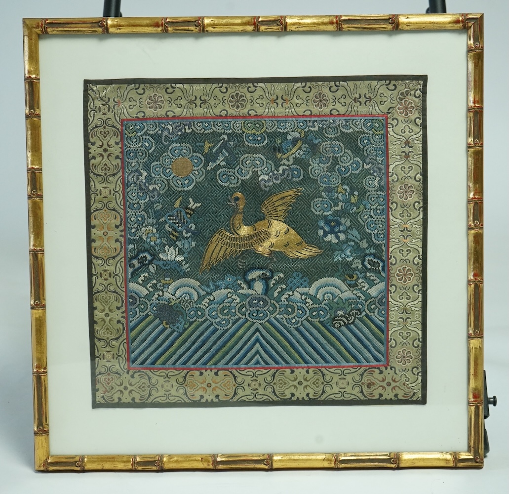 A framed late 19th early 20th century Chinese Mandarin Rank Badge. Worked with a gold thread central motif of a Phoenix, surrounded by finely silk embroidered auspicious motifs, clouds and rolling sea beneath. Bordered w